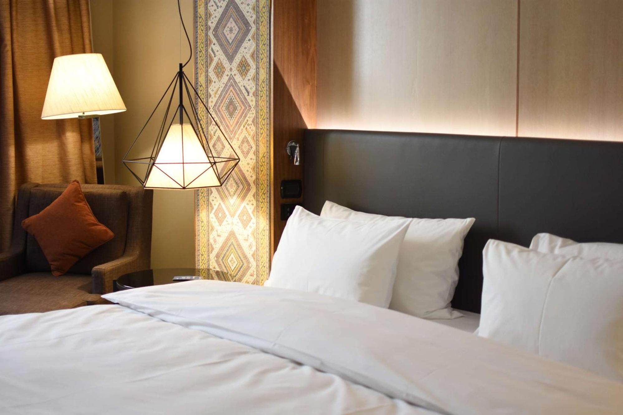Radisson Blu Hotel Yerevan Bagian luar foto A bed with white sheets